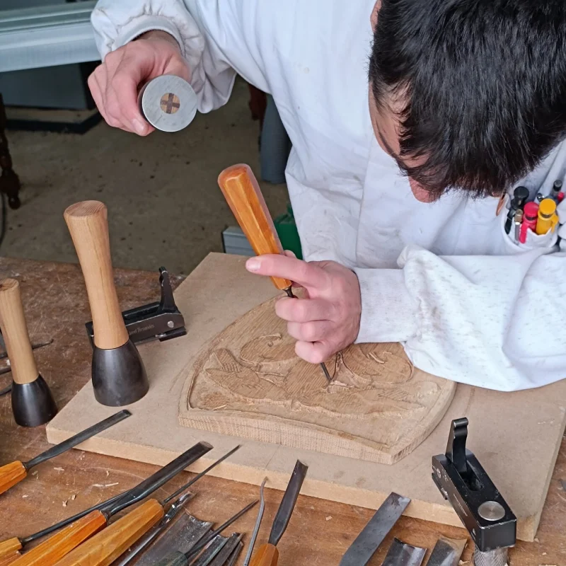 Sculpteur sur bois utilisant un maillet de la manufacture à l'établi